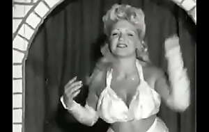 Curly blonde with huge special takes part in an erotic performance of the 60s