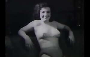 A mature lady with dark silken hair takes part in the filming of a 60s porn film