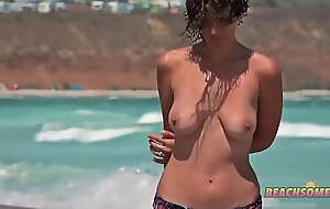 Une fille se balade sein nue a la plage a côté de sa mère