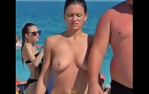 Une mature se balade les seins nue en présence de son mari a refrigerate plage