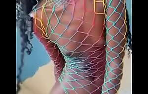 Skinny ebony riding dildo in a rainbow colored fishnet