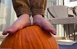 Boy bare feet tears up pumpkin and plays alongside it